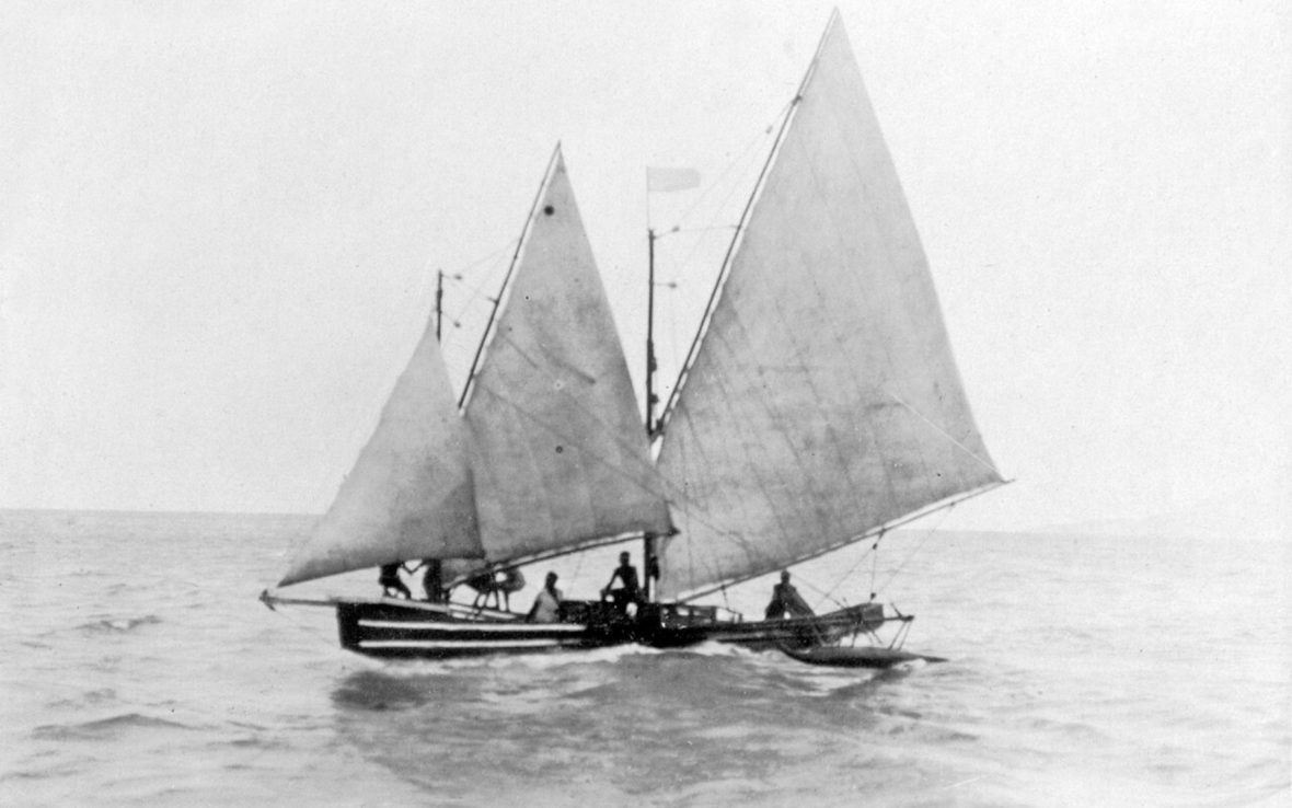 Black and white photo of canoe with sails