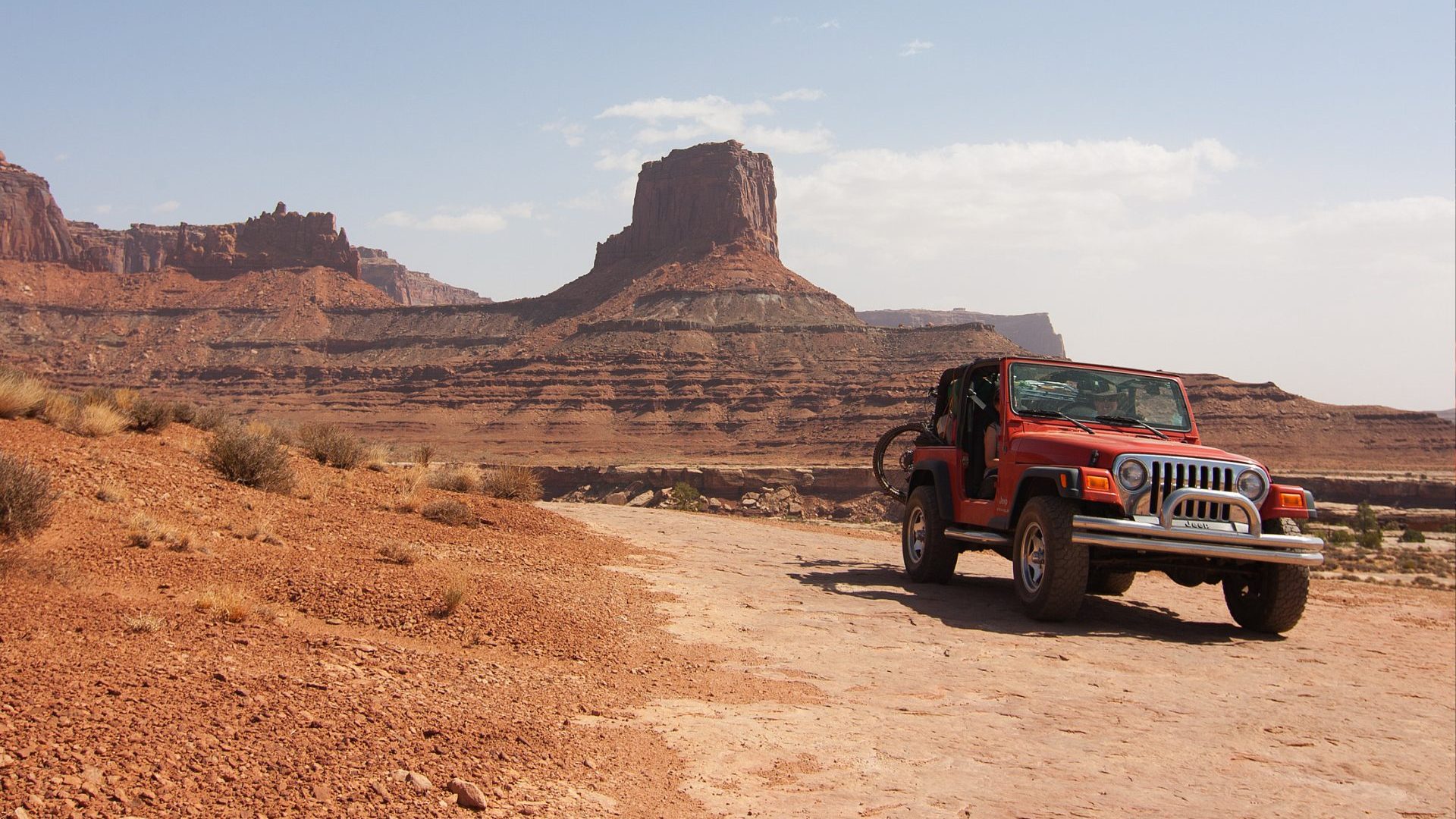 Red truck goes off-roading in red rock landscape