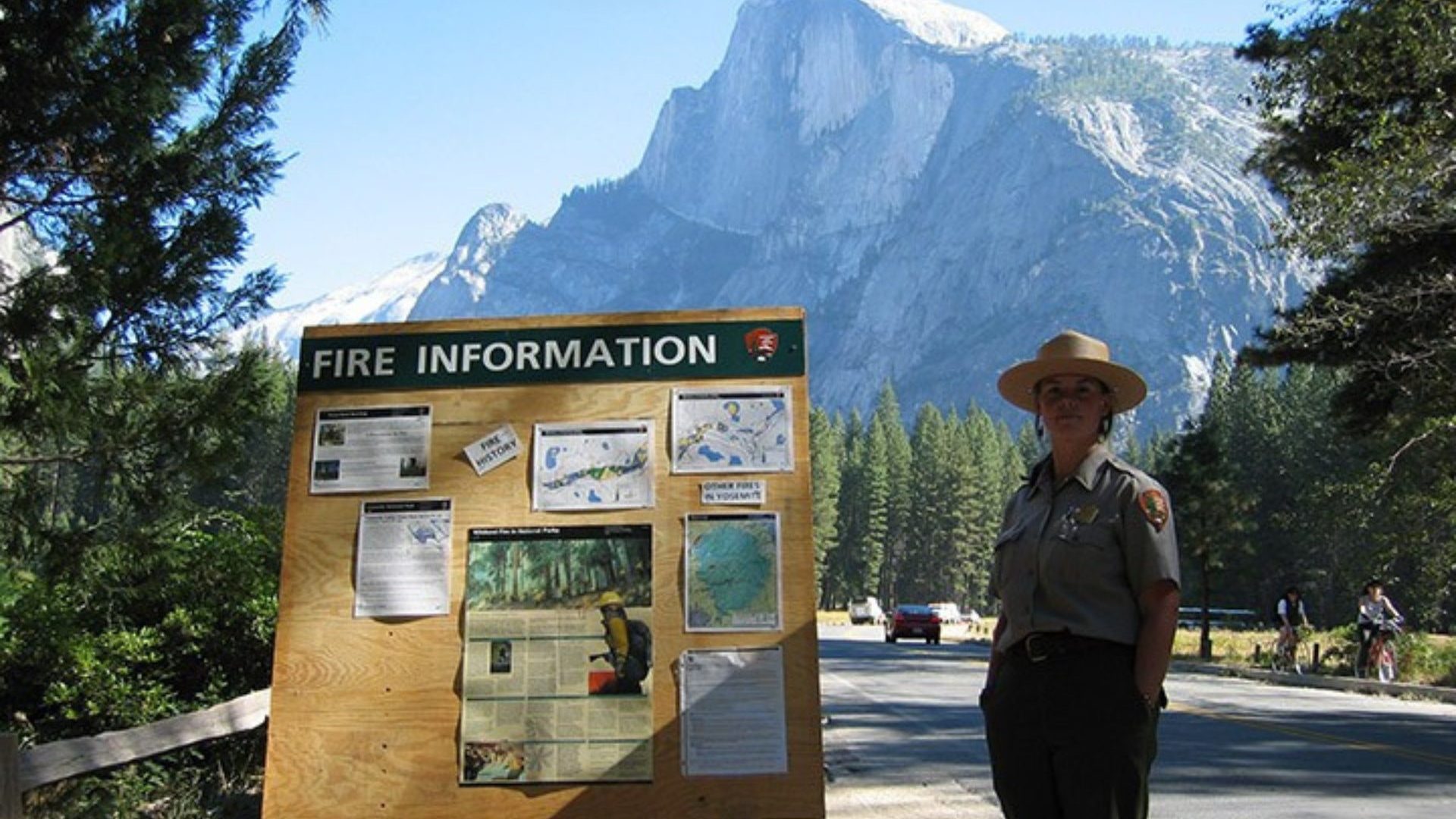 Park ranger stands beside emergency board