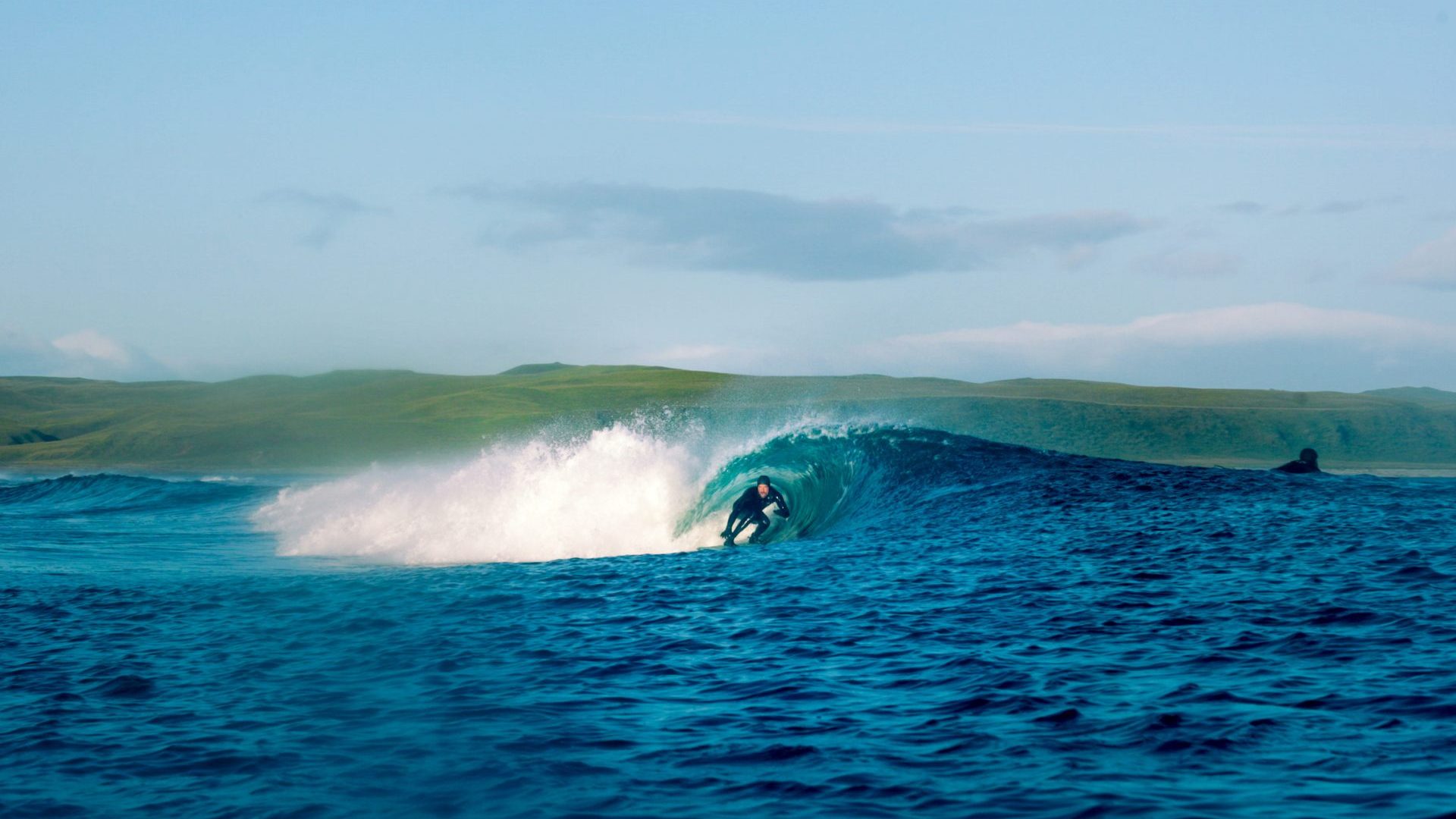 Man surfs barrel wave.