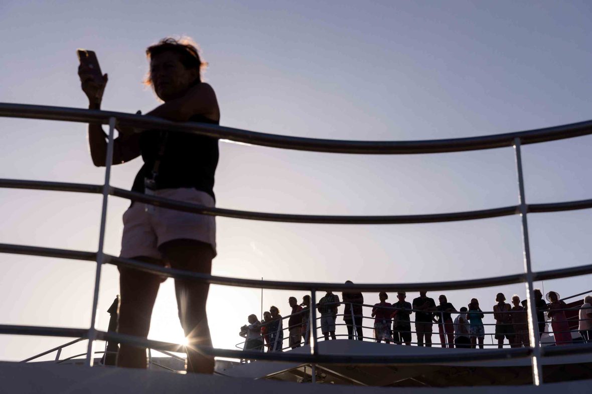 Silhouettes of passengers on the deck of the Aranui.