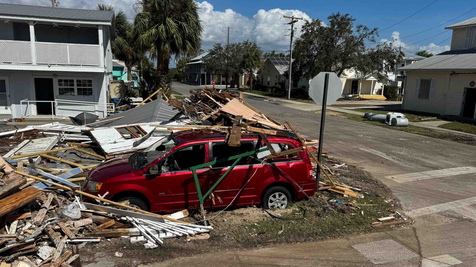 A car amid wreckage from buildings