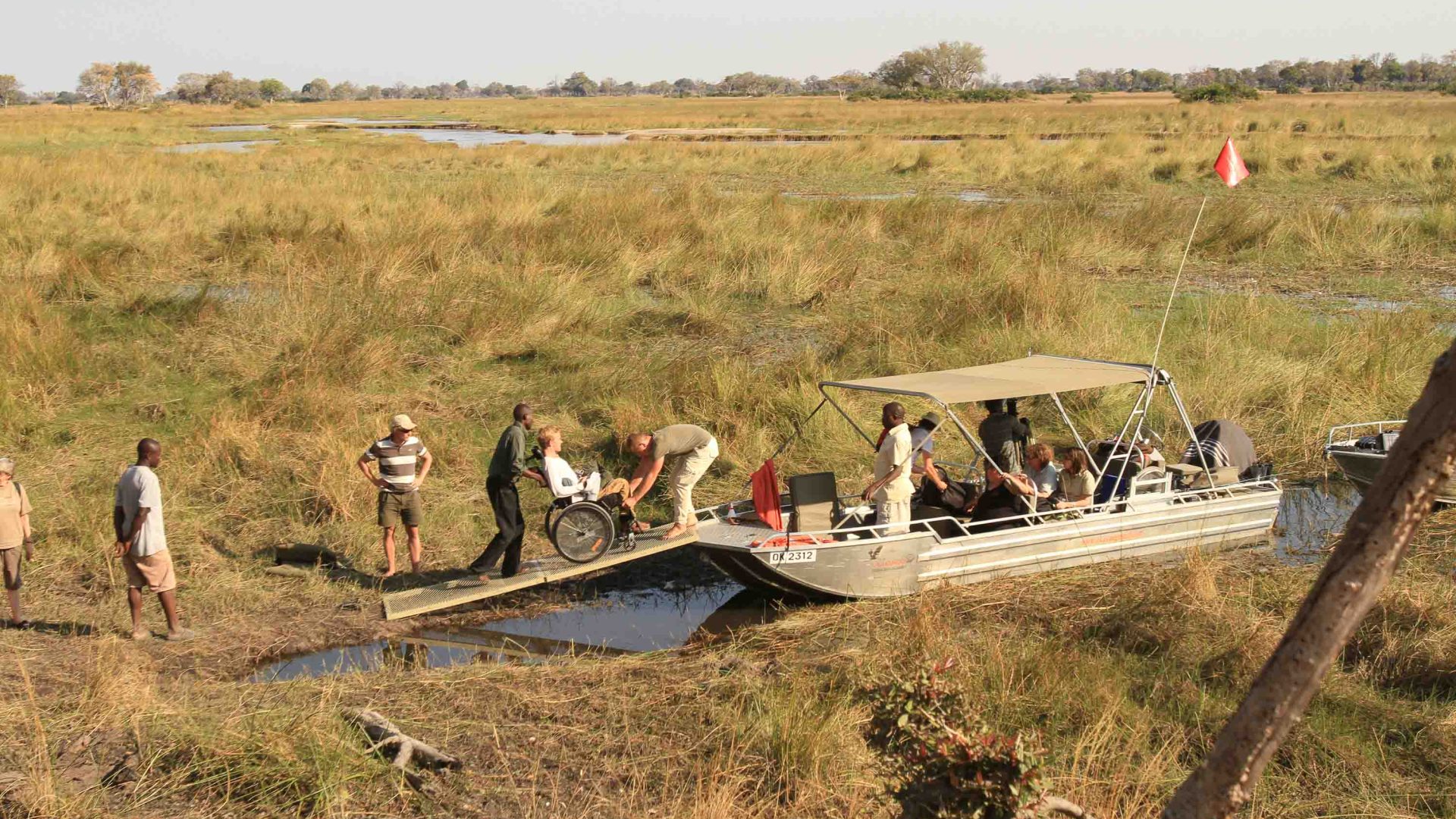 A person in a wheelchair is aided on to a boat in the Delta.
