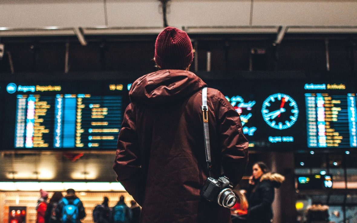A traveler looks at the departures board in a train station.