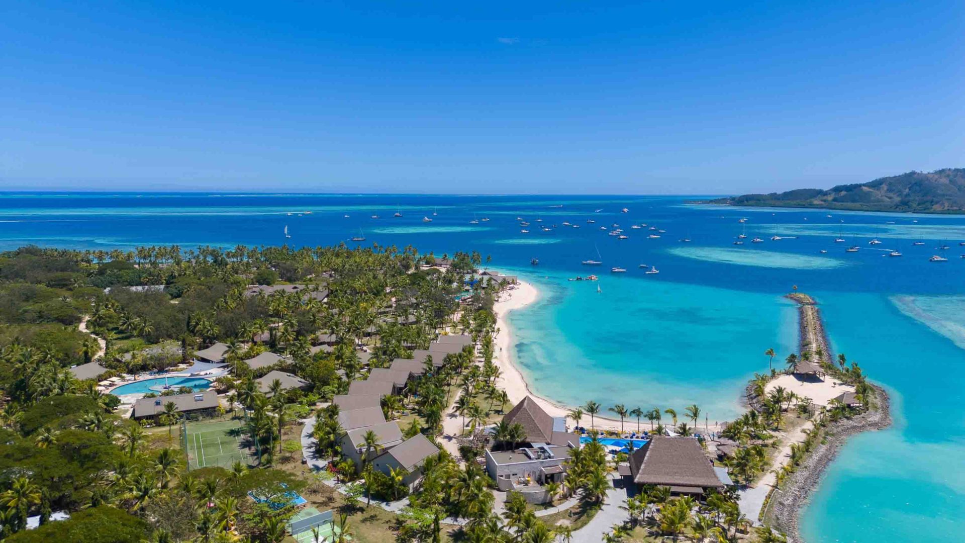 A drone shot of a resort that leads down to the sea.