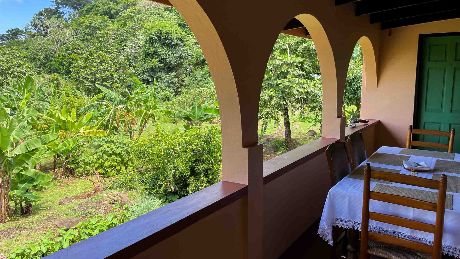 Arched windows open from a patio to views of a green garden.