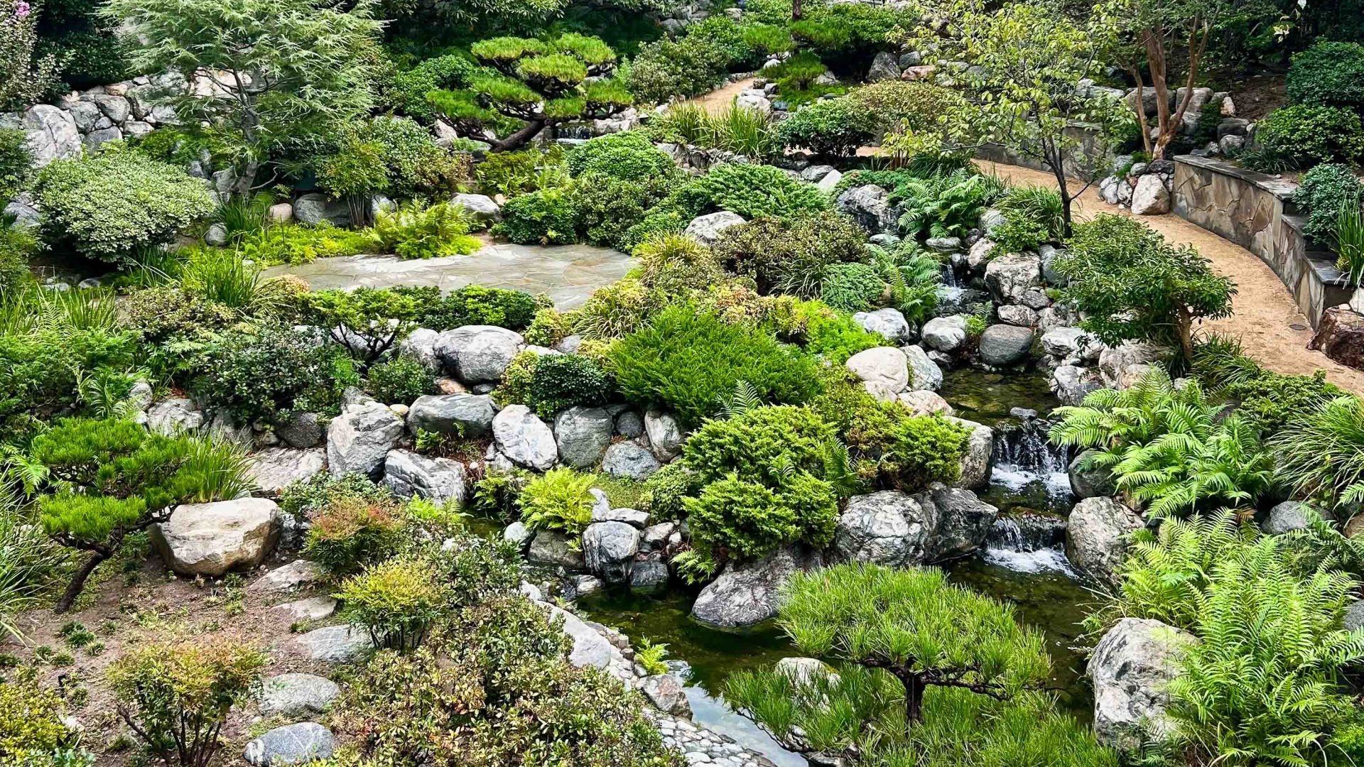Streams and waterfalls in lush green gardens.