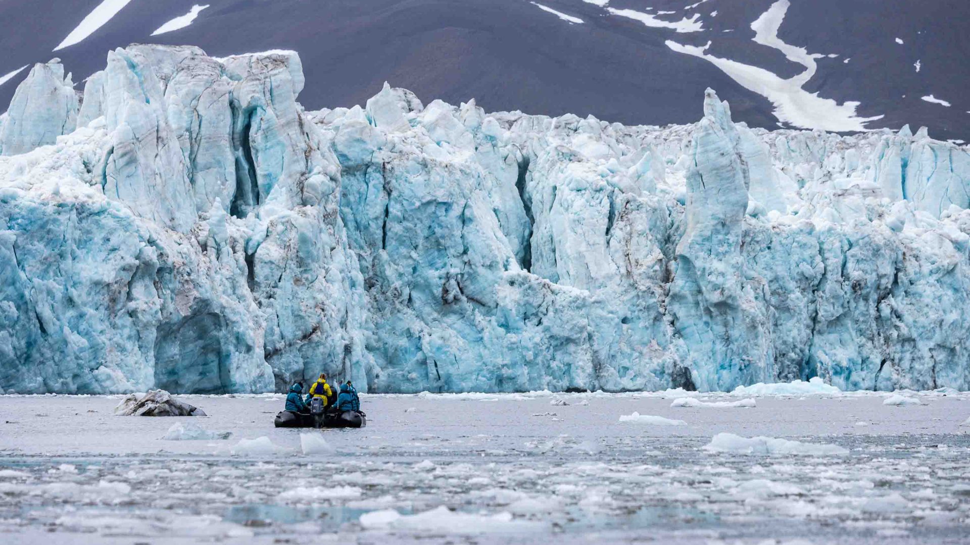 A zodiac approaches a glacier.