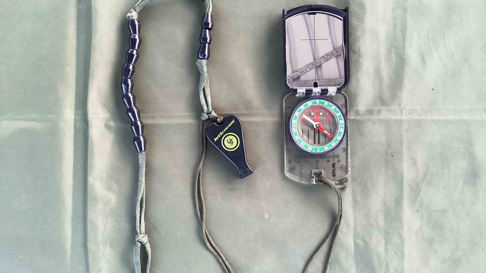 A compass set on a green piece of fabric.