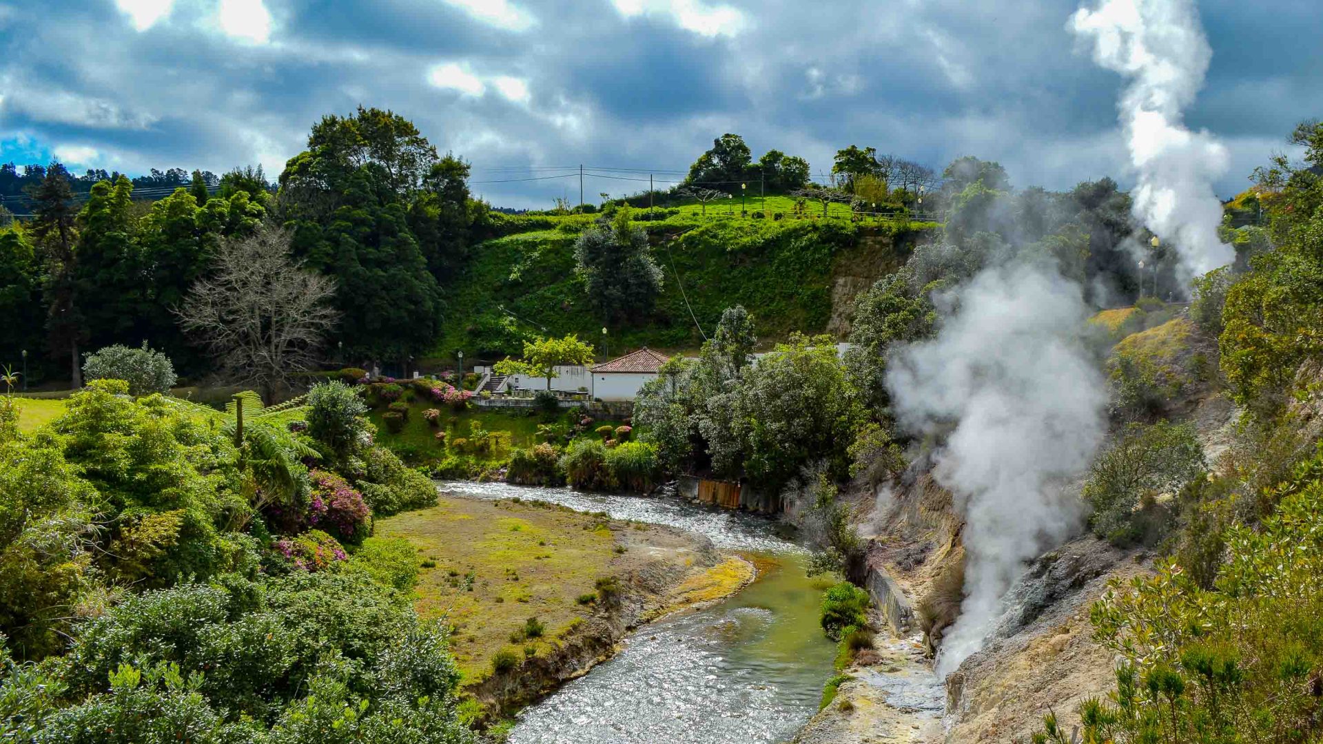 A town with a river and steam coming from the earth.