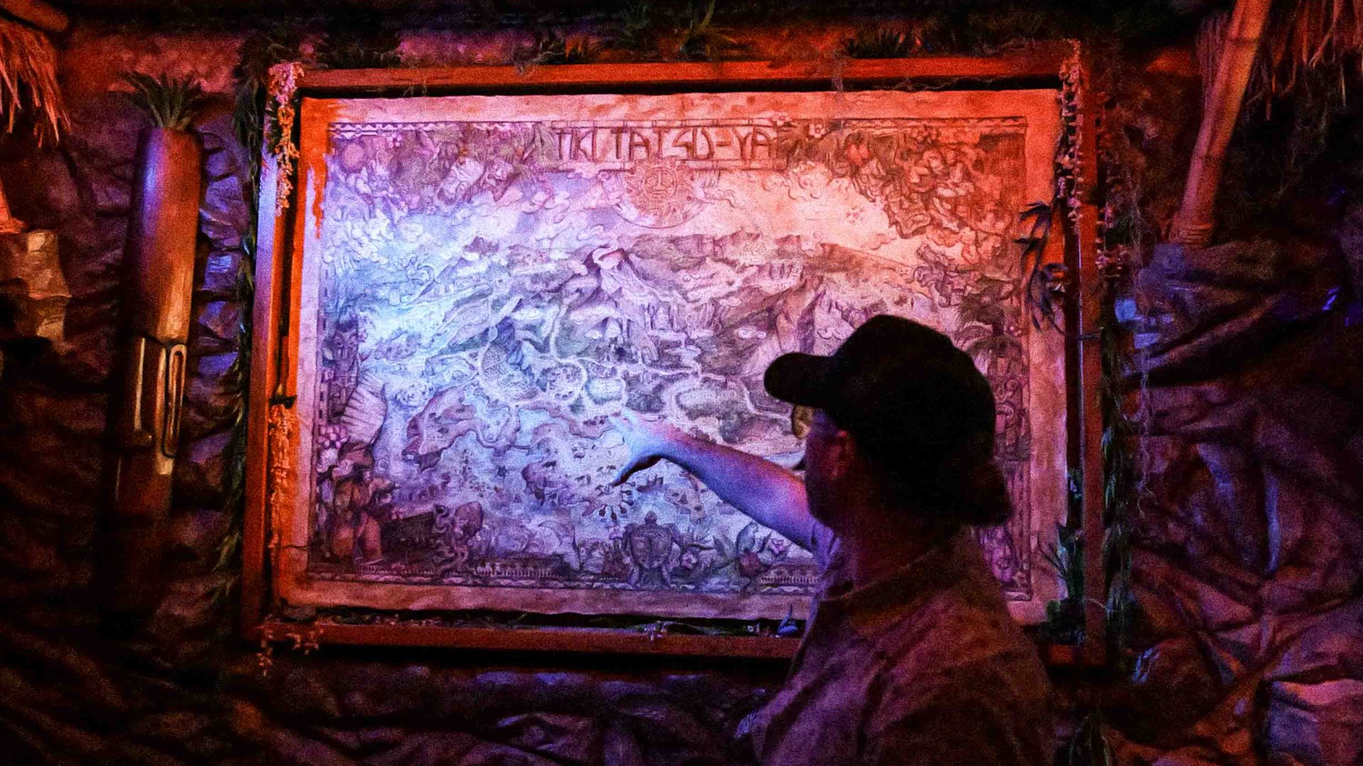 A person points at some art on the wall.