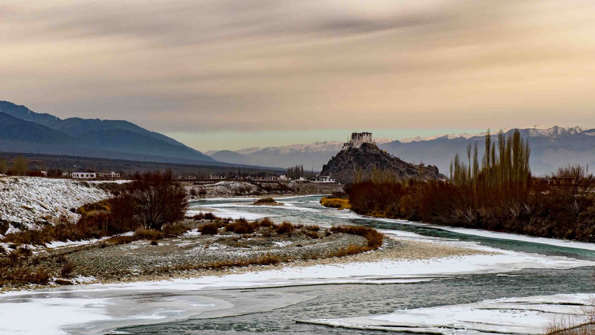 A river, temple, mountains and homes.