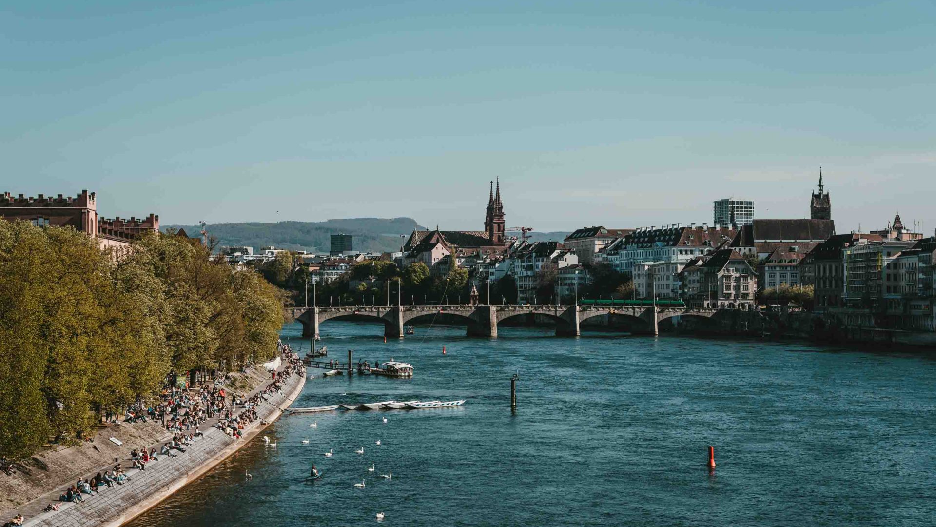 A river with a bridge. People float in the river on floaties.