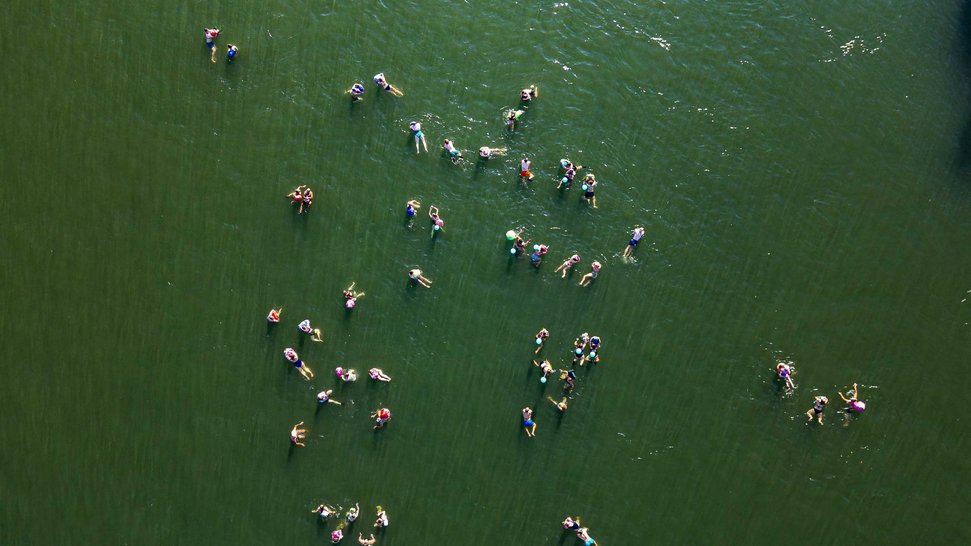 A drone photo of people swimming in a river.